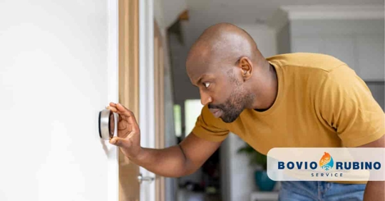 man adjusting thermostat